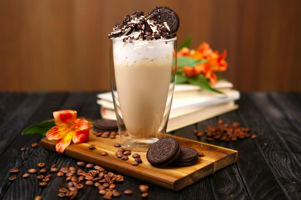 Glass with coffee cocktail with whipped cream and cookie
